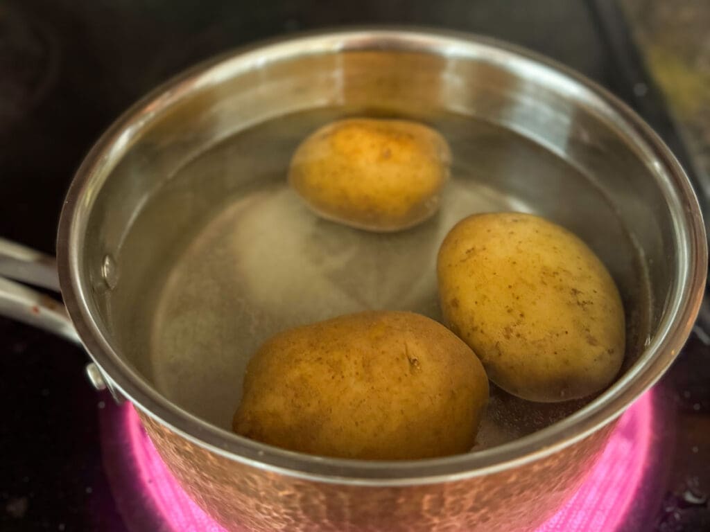 Faire bouillir les pommes de terre entières avec la pelure